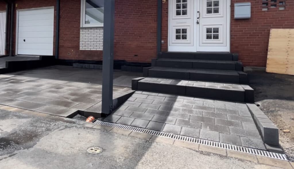 Hauseingang mit dunklem Pflaster und Blockstufen